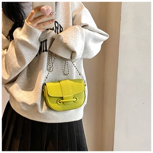 Mirror selfie showing a lemon green litchi grain mini crossbody bag with silver chain strap