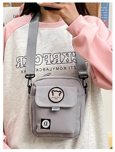 Detail view of gray canvas crossbody bag with cute bear embroidery and adjustable strap