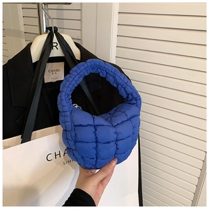Detail of royal blue quilted bubble bag texture and soft puffed handle design