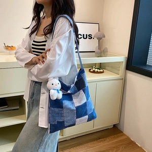 Blue denim patchwork tote bag with a white plush rabbit charm in a modern street style