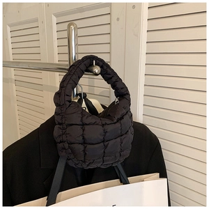 Detailed close-up of a black quilted bubble handbag featuring textured puff fabric and silver zipper