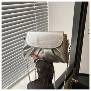 Gros plan du sac bandoulière argenté plissé avec chaîne en métal et texte gravé chic