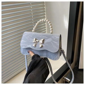 Detail of light blue marble pattern PU leather crossbody bag with pearl handle and bow