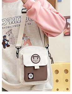 Detail of the canvas messenger bag with a cute bear patch and adjustable nylon strap
