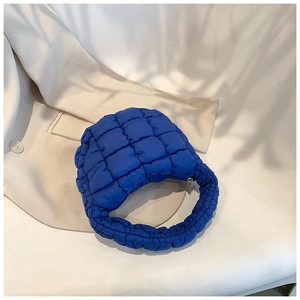 Detail showing bright blue quilted bubble texture and fabric of the mini cloud handbag