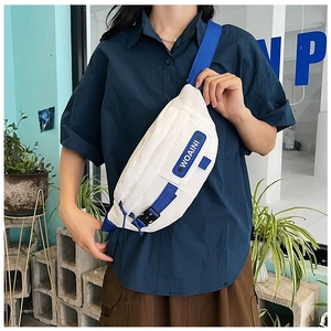 Close-up of white nylon chest bag with blue webbing and WOAINI decorative label detail