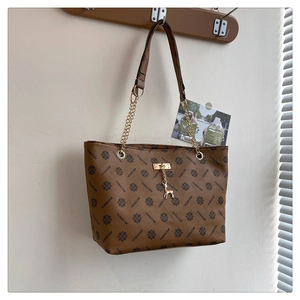 Detailaufnahme der braunen Einkaufstasche mit Monogramm und goldenem Hirschanhänger