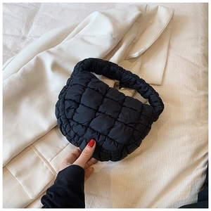 Detail view of black quilted bubble bag with soft nylon fabric and thick handle
