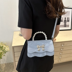 Fashionable light blue square crossbody bag with pearl handle and silver bow detail