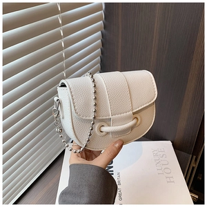 Close-up of white pebble grain PU leather saddle bag with silver beaded chain strap