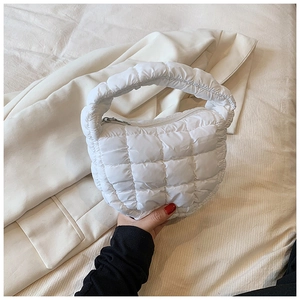 Detailed close-up of white quilted cloud bag with zipper and puffy texture detail