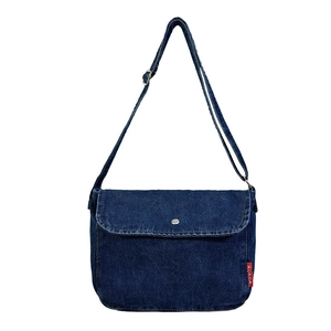 Classic blue denim messenger bag with adjustable strap and flap closure on white background