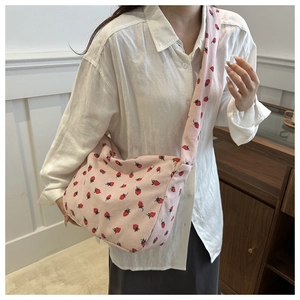 Détail d'un sac fourre-tout en velours côtelé rose pâle avec imprimés fraises rouges