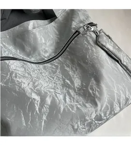 Close-up of metallic silver tote bag with pleated texture and silver hardware