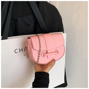 Detail view of pink lychee pattern leather mini saddle bag with silver beaded chain strap