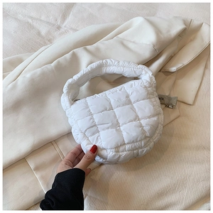Detail of white quilted cloud handbag featuring soft puffer texture and checkered stitching