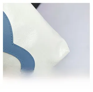 Detail shot of shiny wrinkled faux leather with blue appliqué and metal rivet accent