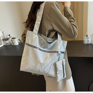 Detail of silver-grey pleated tote bag showing large capacity and metallic texture