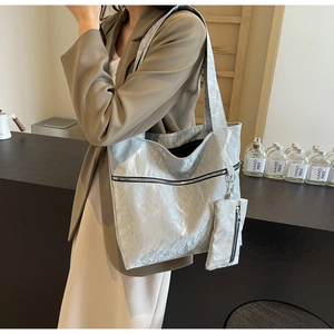 Detail of silver metallic tote bag with crinkle texture and matching small pouch