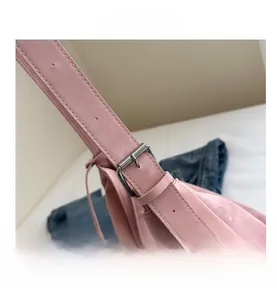 Detail of pink faux suede tote bag featuring adjustable shoulder strap and silver metal buckle