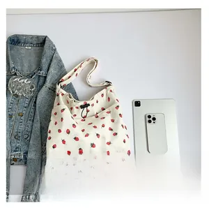 Corduroy strawberry tote bag shown with tablet and phone for size comparison