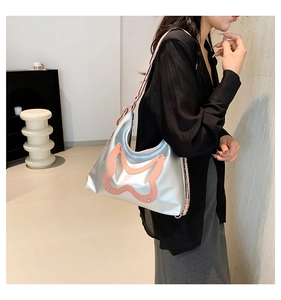 Detail of silver metallic shoulder bag with pink butterfly patchwork and rivet studs