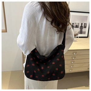 Détail du sac cabas en velours côtelé noir avec motif brodé de fraises rouges