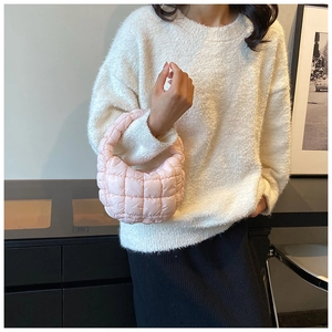 Pink quilted puffer bag with cloud pleats shown on a model in a cozy indoor setting