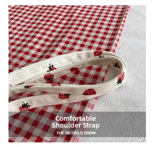 Close-up of comfortable corduroy shoulder strap with red strawberry embroidery on tote