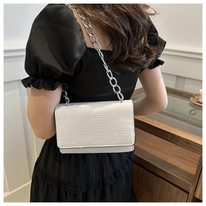 White faux crocodile leather shoulder bag with a chunky silver chain on a female model