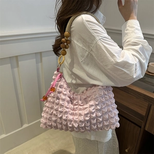 Pink pleated minimalist underarm bag with rope handle and decorative beads