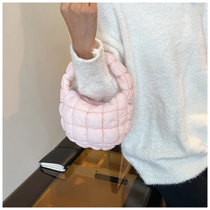 Detail of light pink quilted cloud bag featuring soft puffy texture and zipper closure