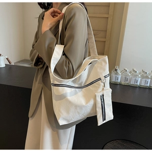 Detail of a large off-white tote bag with a small matching zipper pouch for daily use