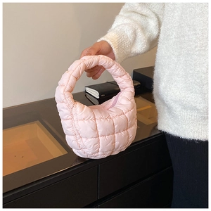 Detailed view of pink quilted puffer handbag with soft fabric and bubble texture design