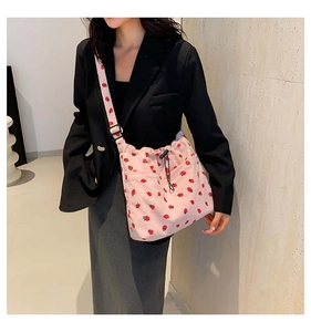 Pink corduroy bucket bag with strawberry pattern and drawstring closure detail