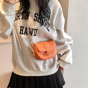 Fashionable orange saddle bag in lychee leather with a silver metal ball chain strap