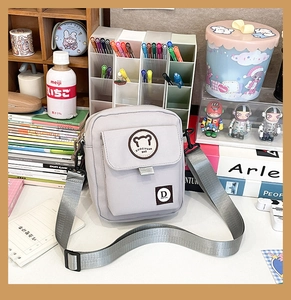 Detail of lavender canvas crossbody bag with cute bear patch and adjustable nylon strap