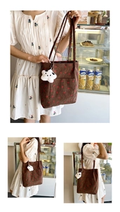 Detail of brown corduroy tote bag with strawberry embroidery and star plush charm