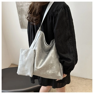 Detail of silver textured tote bag with matching inner pouch and weathered metallic finish