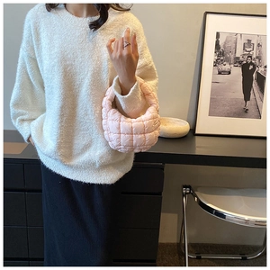 Detailed shot of pink quilted puffy cloud bag with semi-circle design and soft texture