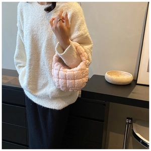 Detail of light pink quilted bubble bag showing soft nylon hobo texture and trendy design