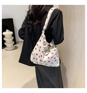 Detailed back view of a white corduroy tote bag with red strawberry prints and drawstring