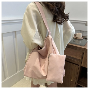 Detail view of pink suede tote bag set with matching coin purse in an elegant indoor setting