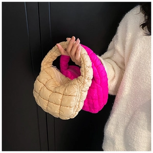 Close-up of quilted puffer mini handbags in beige and vibrant pink with metallic zippers