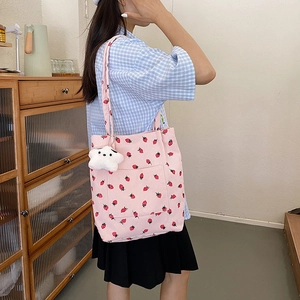 Pink corduroy tote bag with strawberry print and star plush pendant detail