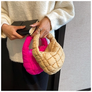 Close-up of bright pink and beige mini quilted cloud bags with soft padded texture