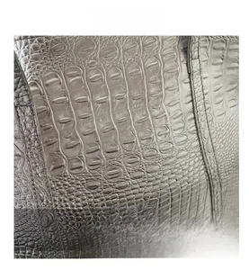 Detail of silver-grey crocodile pattern texture with metallic finish and fine stitching on bag