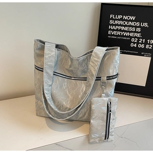 Detail of silver wrinkled texture tote bag set with matching zipper pouch and metallic finish