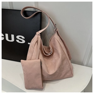 Pink suede-like tote bag and matching zipper pouch set shown on a modern white display
