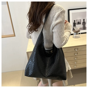 Close-up of the black woven texture and leather strap on this retro style hobo shoulder bag